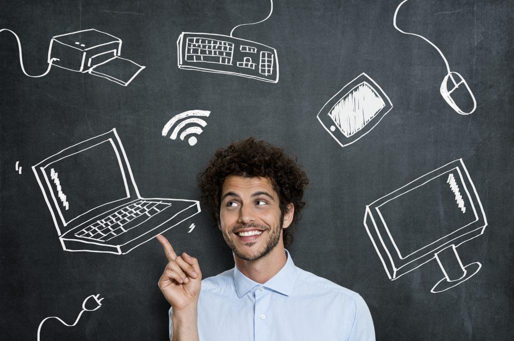 Portrait Of Young Man With Different Computer Technology Over Gray Background