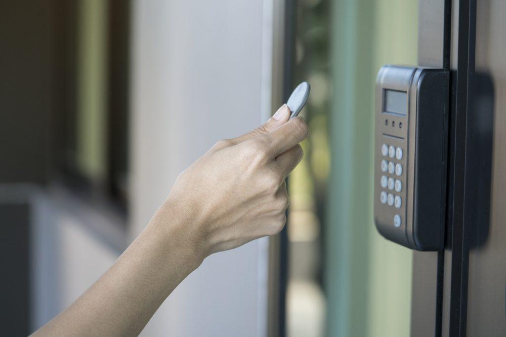 young woman using RFID tag key to open the door