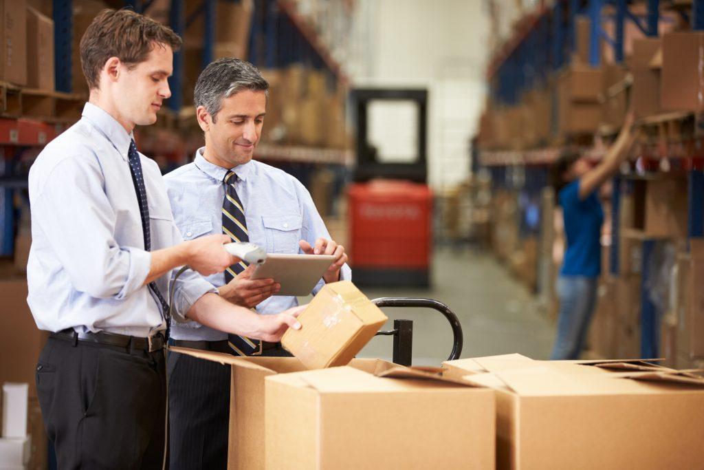 Businessmen Checking Boxes With Digital Tablet And Scanner