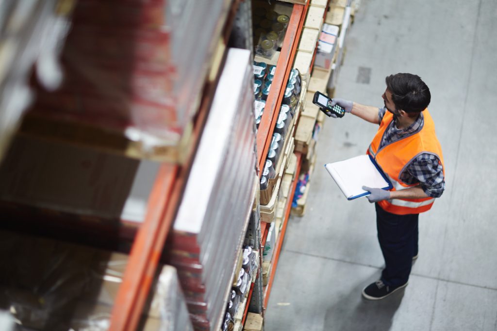 Worker managing stock in a warehouse using a computer