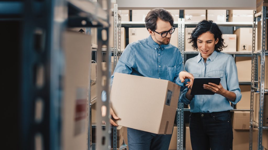 Two warehouse workers using mobile devices 