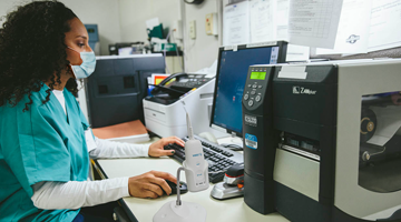 healthcare worker printing labels. 