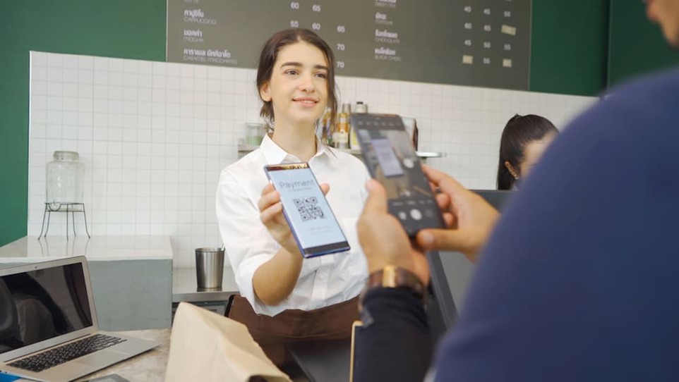 A cafe worker using a QC code 